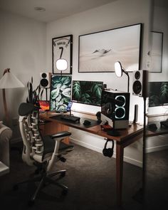 a desk with two computer monitors sitting on top of it next to a white chair