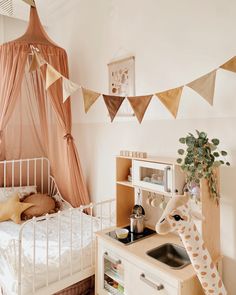 a child's bedroom with a giraffe statue and toy kitchen set in the corner