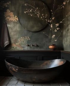 a bathtub sitting in the middle of a bathroom next to a wall with flowers on it