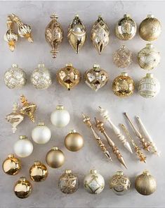 there are many different types of ornaments on the table, all in gold and white