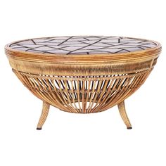 a wicker coffee table with an oval glass top and metal legs, on a white background