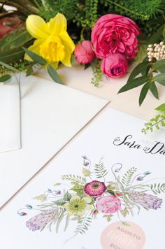 flowers are sitting on the table next to an envelope