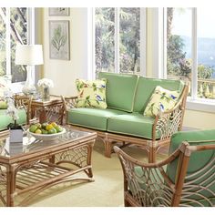 a living room filled with green furniture and lots of wood flooring on top of a hard wood floor