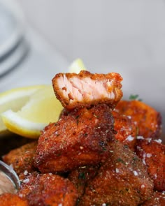 a close up of food on a plate with lemon wedges