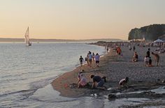 many people are on the beach at sunset