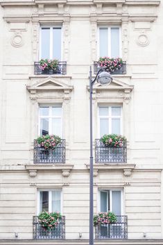 an apartment building with two balconies and flower boxes on the windows sill