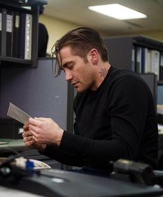 a man sitting at a desk with a knife in his hand