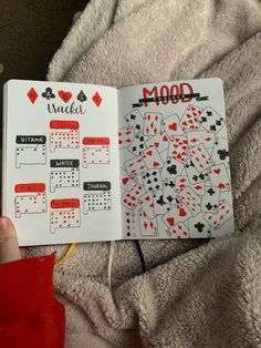 a person holding up a notebook with playing cards on it and the words mood written in red