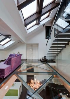 a purple couch sitting in the middle of a living room next to a stair case