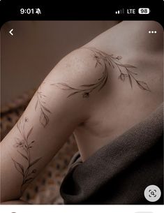 the back of a woman's arm with flowers on it, and an arrow tattoo