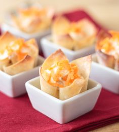 small bowls filled with food sitting on top of a red cloth