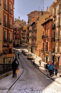 people walking down the street in an old city