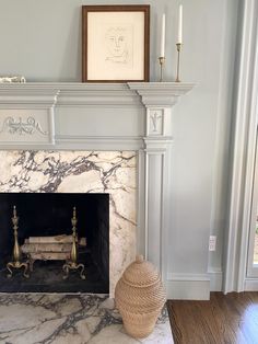 a fireplace in a living room with white marble