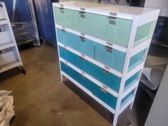 several blue and white drawers stacked on top of each other in a room with metal racks