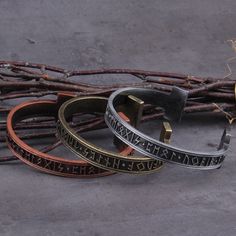 three different colored bracelets sitting next to each other on top of a gray surface