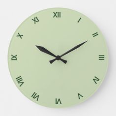 a green clock with roman numerals on the face is shown in black lettering