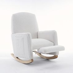 a white rocking chair with a wooden base and footstool in the shape of a recliner