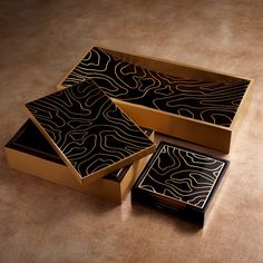 three black and gold boxes sitting on top of a table