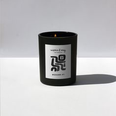 a black candle sitting on top of a white table