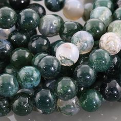 green and white marble beads are stacked on top of each other in this close up photo