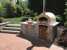 an outdoor pizza oven with firewood in it