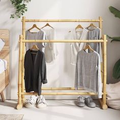 a bamboo rack with clothes hanging on it