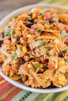 a white bowl filled with mexican food on top of a table