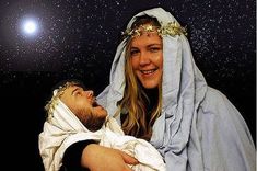 a man and woman dressed up as the nativity scene with stars in the background