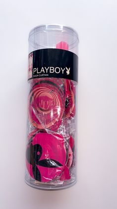 a pink toy car in a clear plastic container on a white surface with black lettering