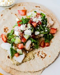 a tortilla with vegetables and feta cheese on top