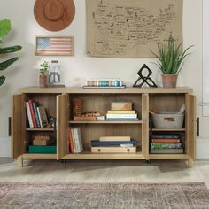 a book shelf with books and plants on it in front of a wall mounted map