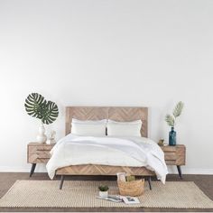 a bedroom with white walls and wooden furniture