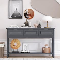 a living room with a gray console table and pictures on the wall above it,