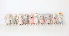 a group of stuffed animals lined up on a white surface with one standing in the middle