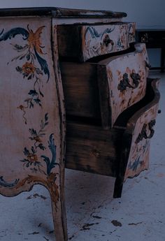 an old wooden dresser with painted flowers on it