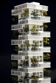 a model of a tall building with trees growing on the top and bottom floors, in front of a black background