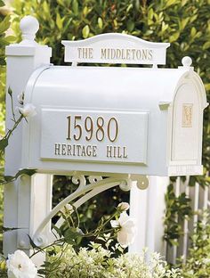 a white mailbox sitting in the middle of some bushes