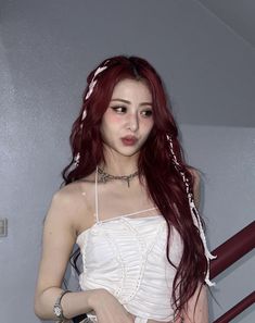 a woman with long red hair wearing a white dress