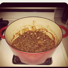 a pot filled with food sitting on top of a stovetop next to a burner