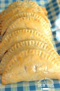 four pastries sitting on top of a blue and white checkered table cloth