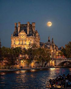 the full moon is setting over an old building on the riverbank in paris, france