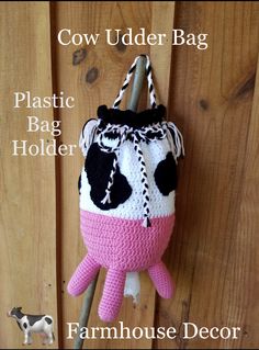 a crocheted cow purse hanging on the side of a wooden door with text overlay that reads,'cow udder bag plastic bag holder farmhousehouse decor '