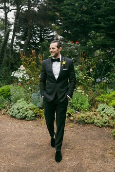 a man in a tuxedo walking down a path