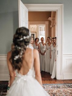 a bride and her bridesmaids are looking in the mirror at their wedding day