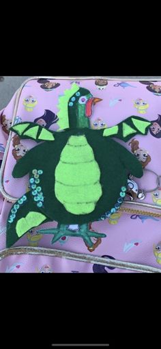 a pink suitcase with a green turtle on it