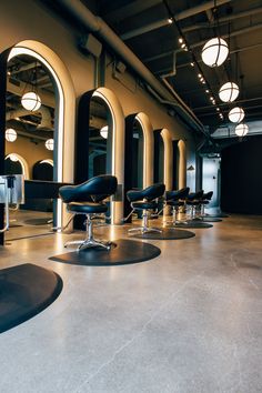 an instagram photo of some chairs in a hairdressing salon with lights on the ceiling