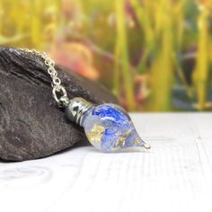 a small glass bottle sitting on top of a rock