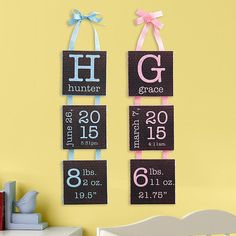 two baby's birth signs hanging on the wall next to a crib