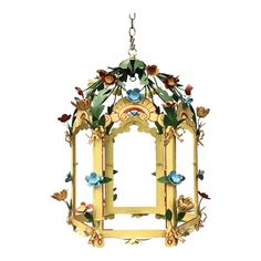 a bird feeder with flowers and leaves hanging from it's side on a white background