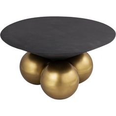 three brass balls are sitting on top of a black table with two gold spheres in the middle